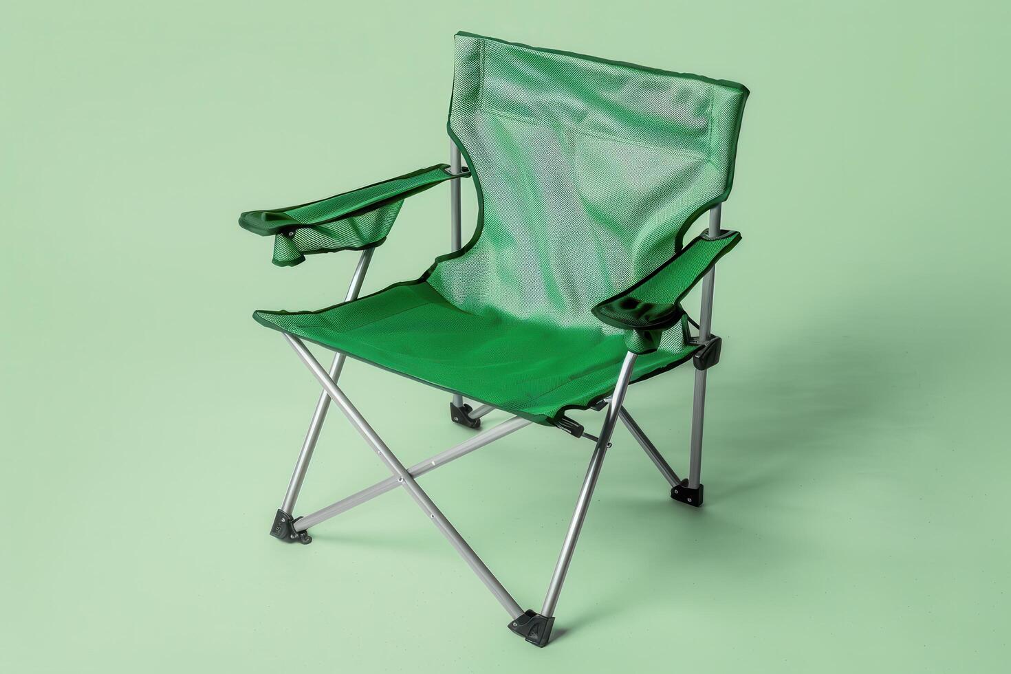 A vibrant green folding chair set against a soft pastel background, ideal for outdoor relaxation or camping moments photo