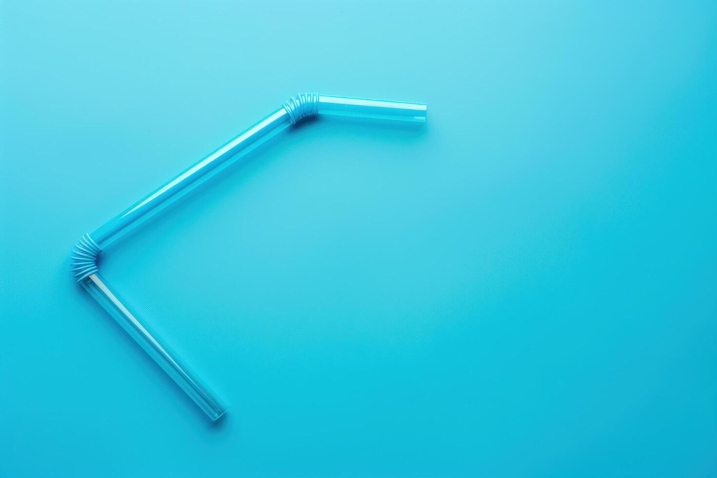 Flexible straws arranged in a playful angle on a vibrant blue background photo