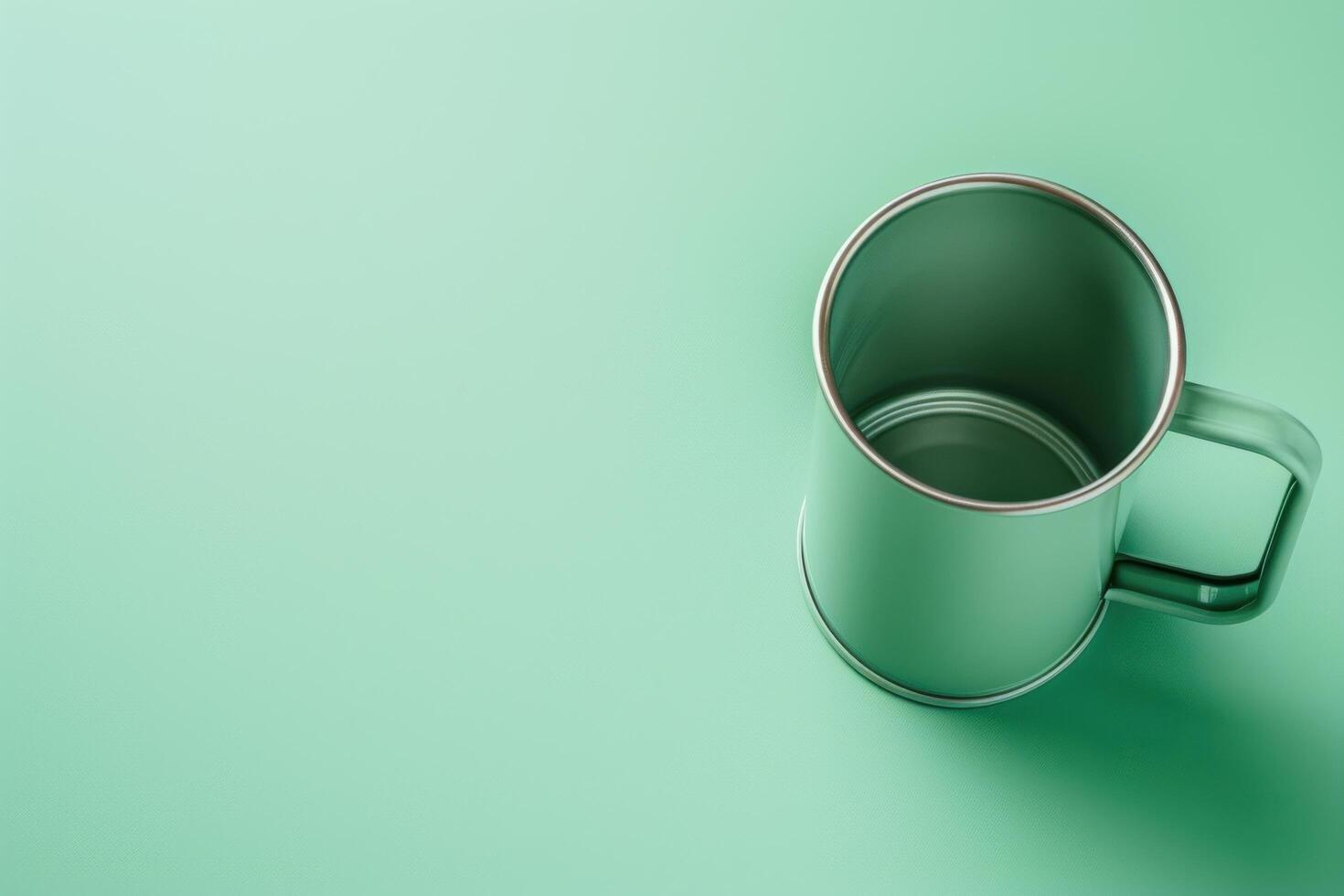A sleek metallic mug rests on a smooth mint green surface, inviting a cozy sip of warmth photo