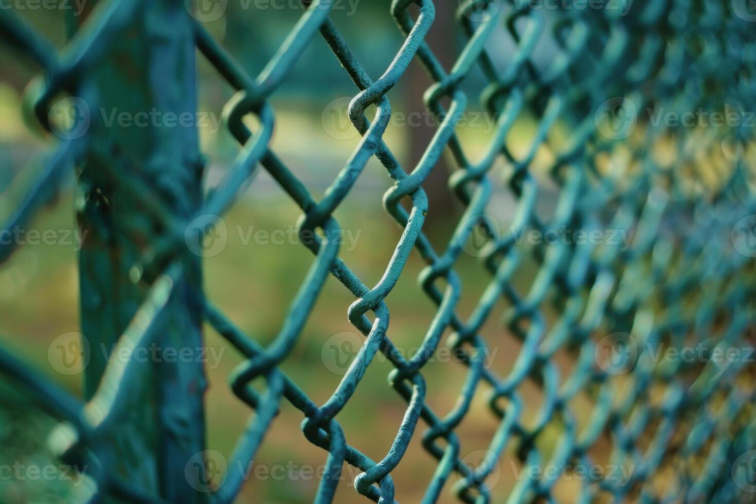 Close-up view of a green chain-link fence in a park during daylight photo
