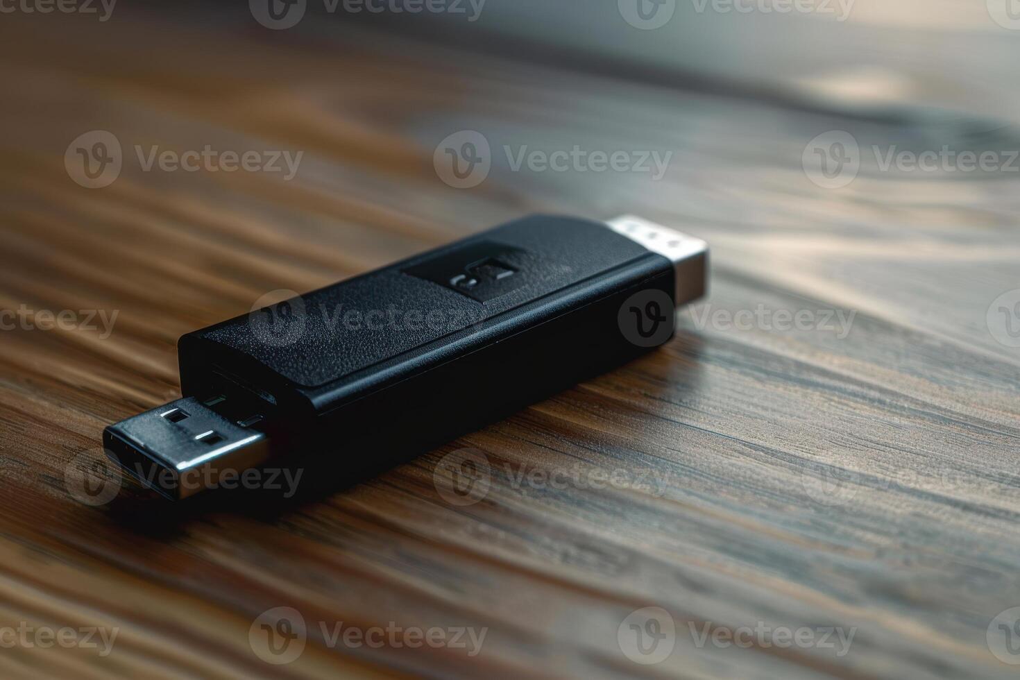 A black USB drive resting on a wooden table in soft natural light photo