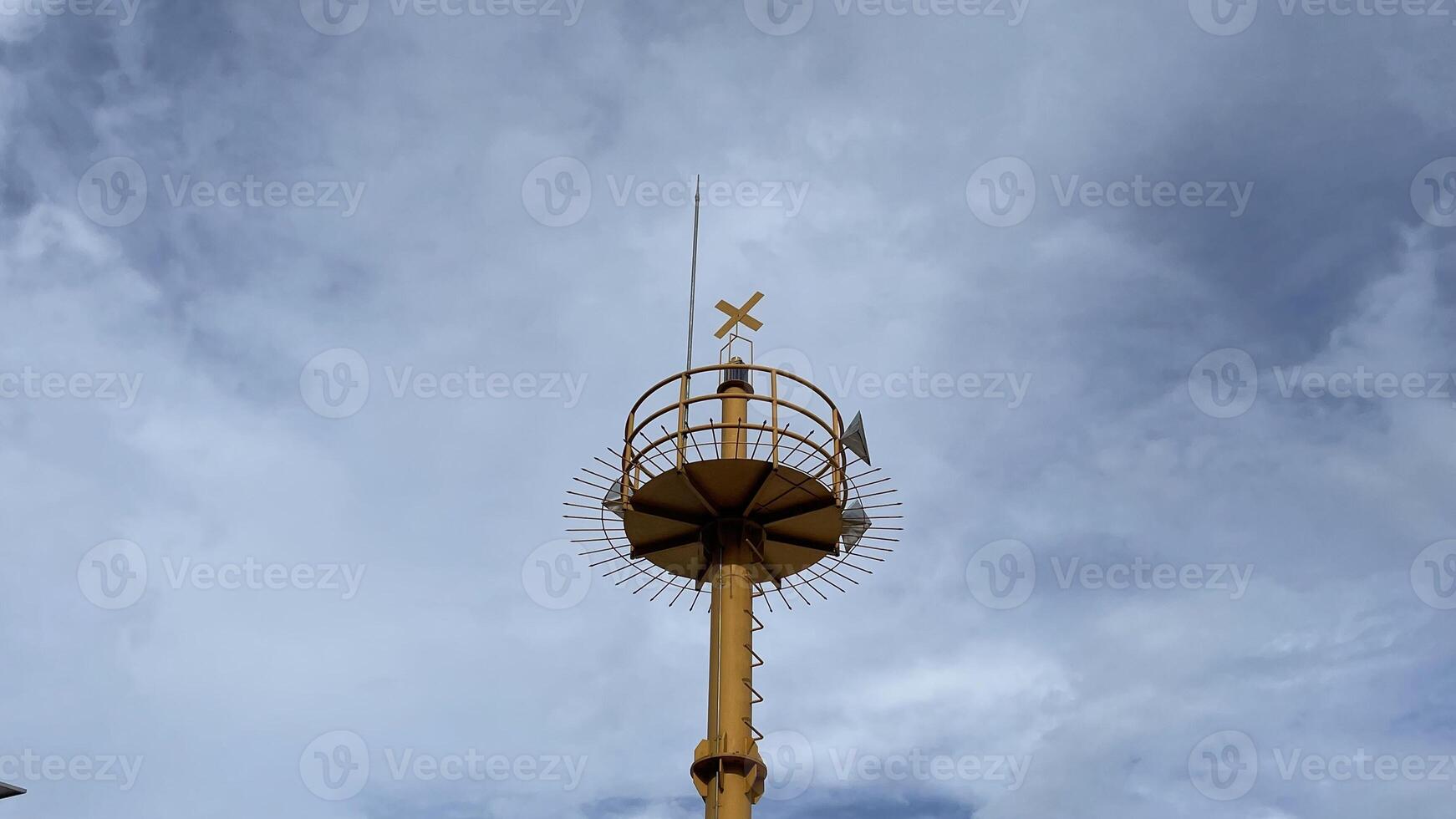 a watchtower that stands firmly painted yellow with spotlights to see the surroundings photo