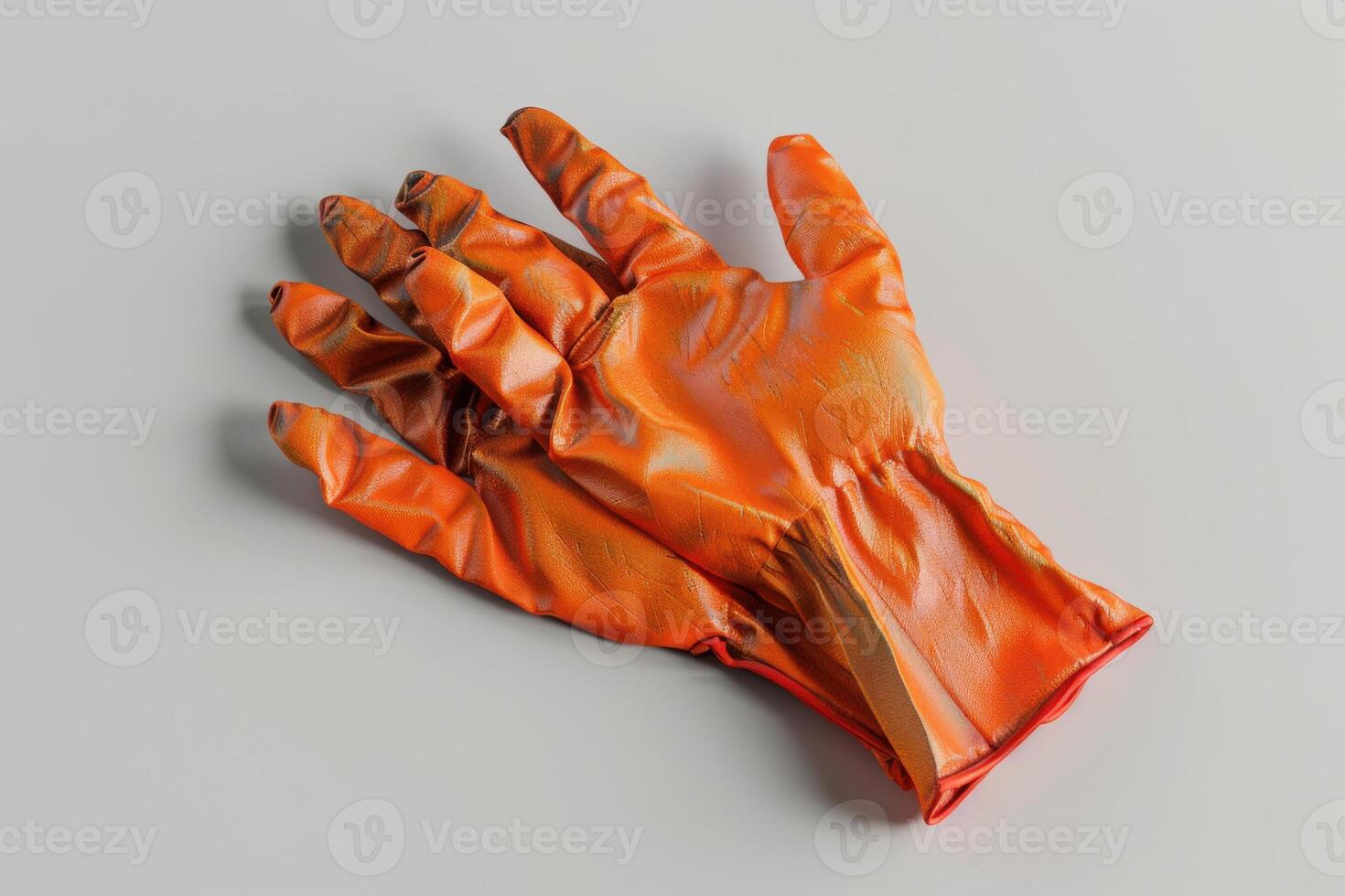 Orange rubber glove resting on a flat surface in a well-lit room photo