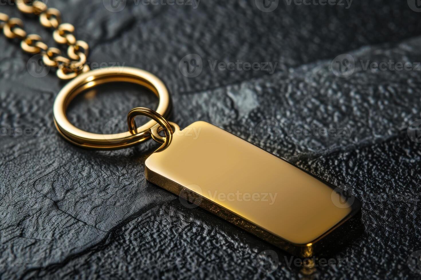 Close-up of a gold pendant with ring on textured black surface photo