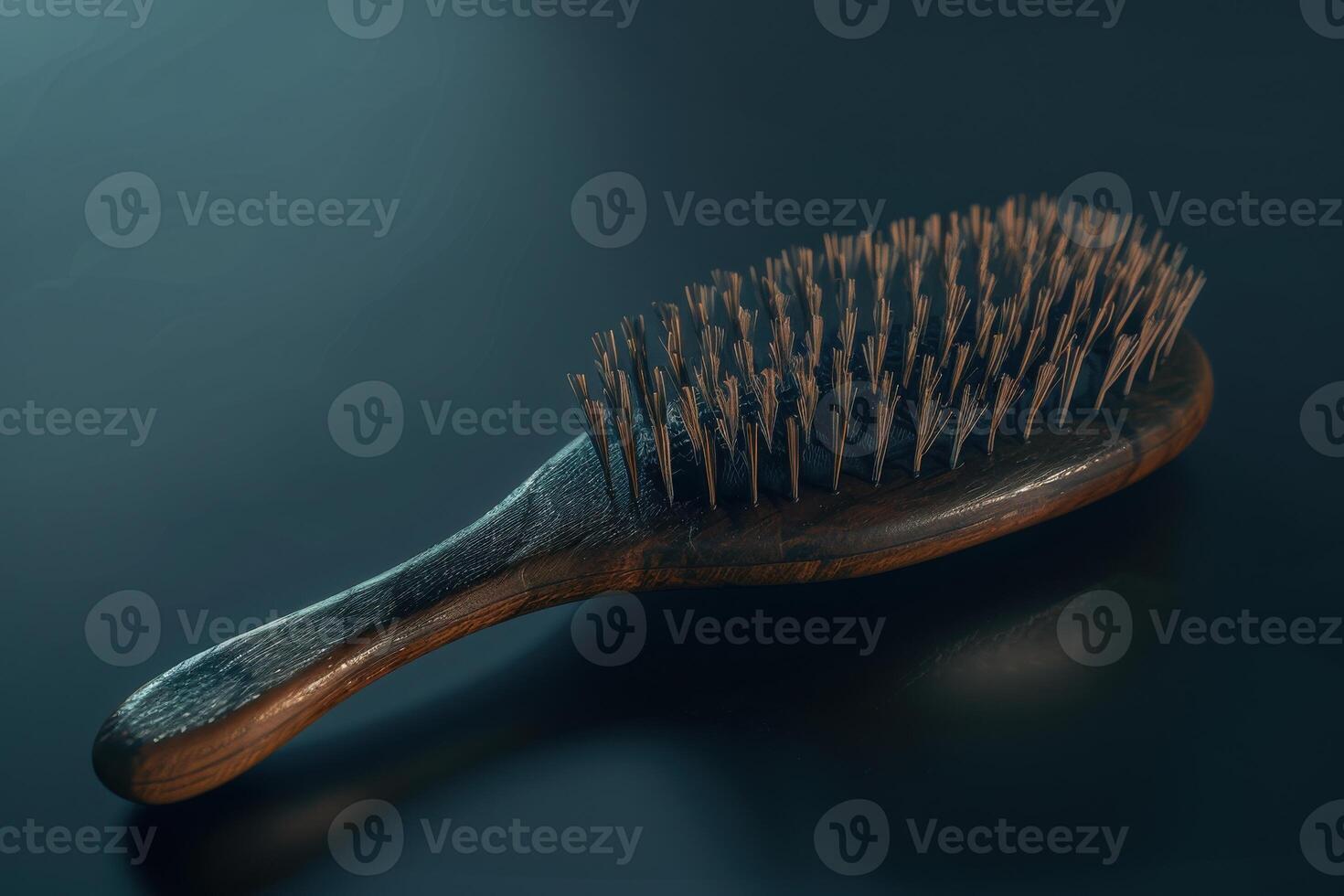A wooden hairbrush with fine bristles resting on a smooth surface in natural light photo