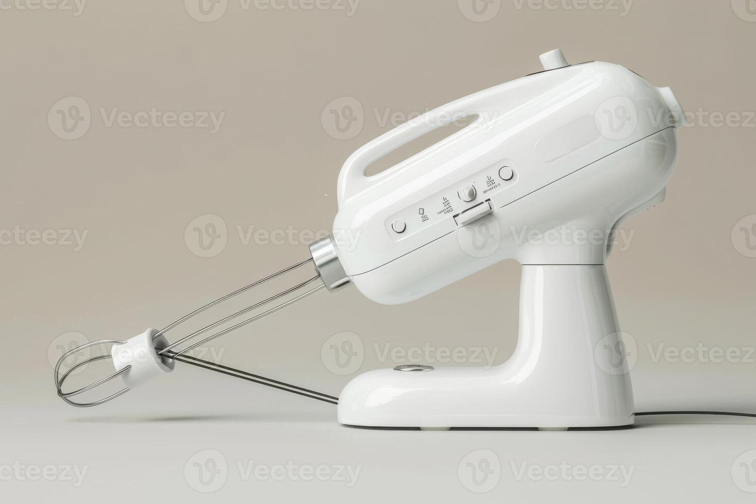 White electric hand mixer on a neutral background with whisks attached in a kitchen setting photo