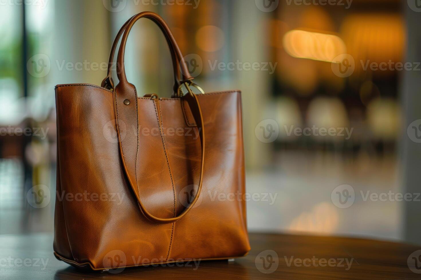 Elegant brown leather handbag displayed on a table in a stylish indoor setting during daylight photo