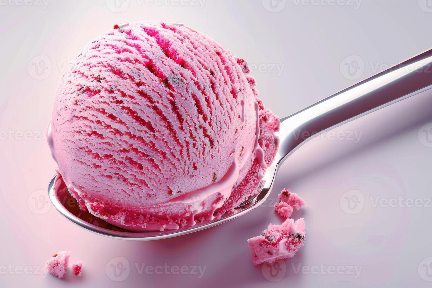 Pink strawberry ice cream scoop on a spoon with scattered crumbs photo