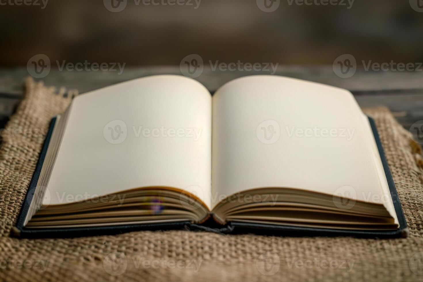 Open blank book resting on burlap fabric in a cozy setting photo