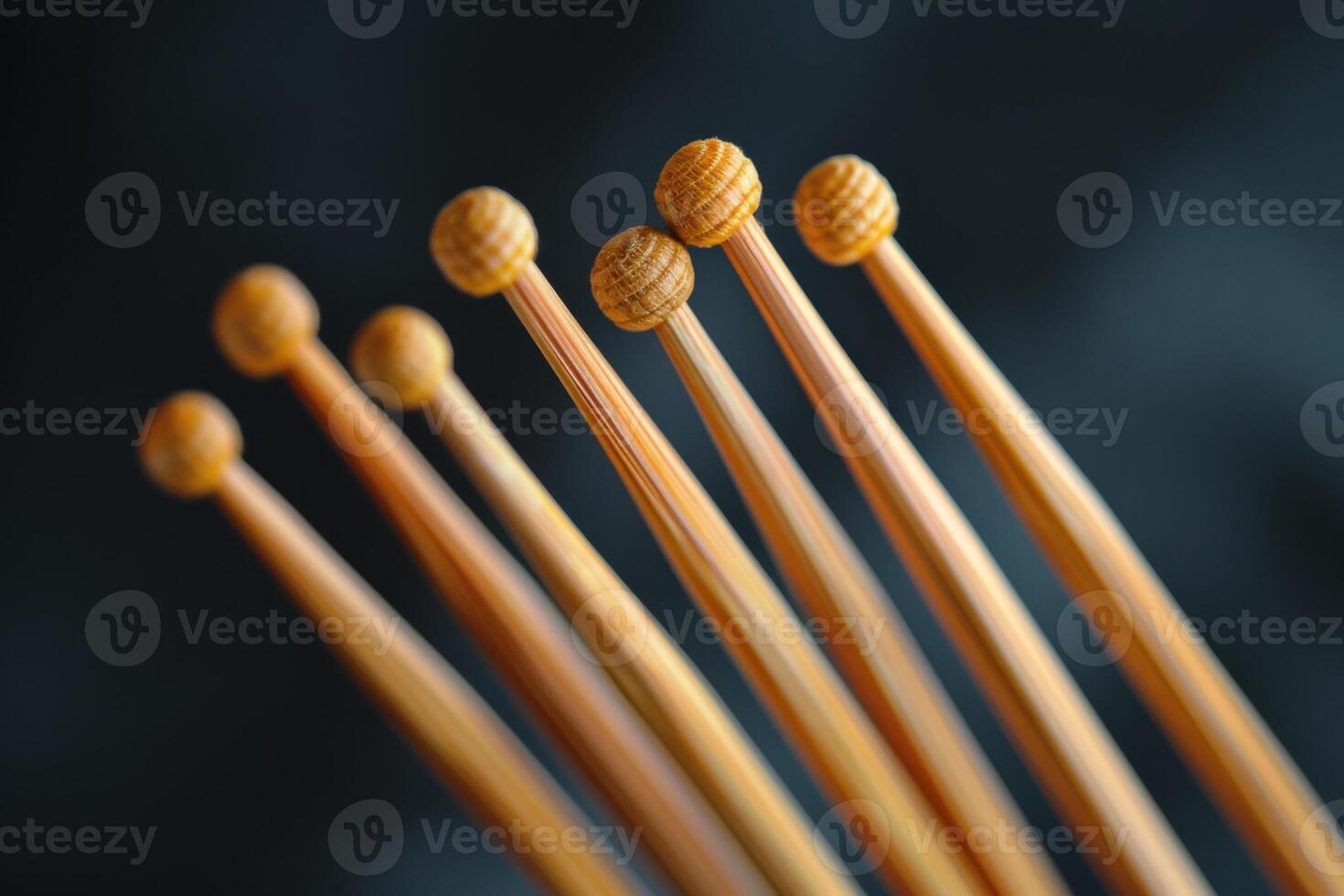 Close-up of wooden knitting needles arranged in a line against a dark background photo