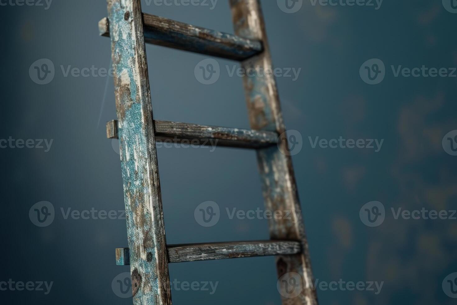 Weathered wooden ladder against a textured blue wall in a rustic setting photo