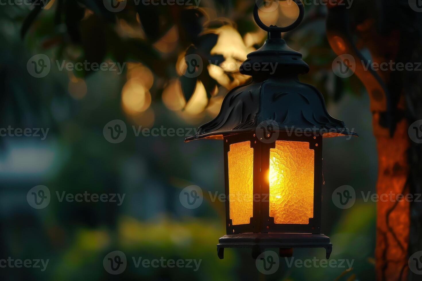 A warm lantern illuminates a peaceful garden at dusk photo