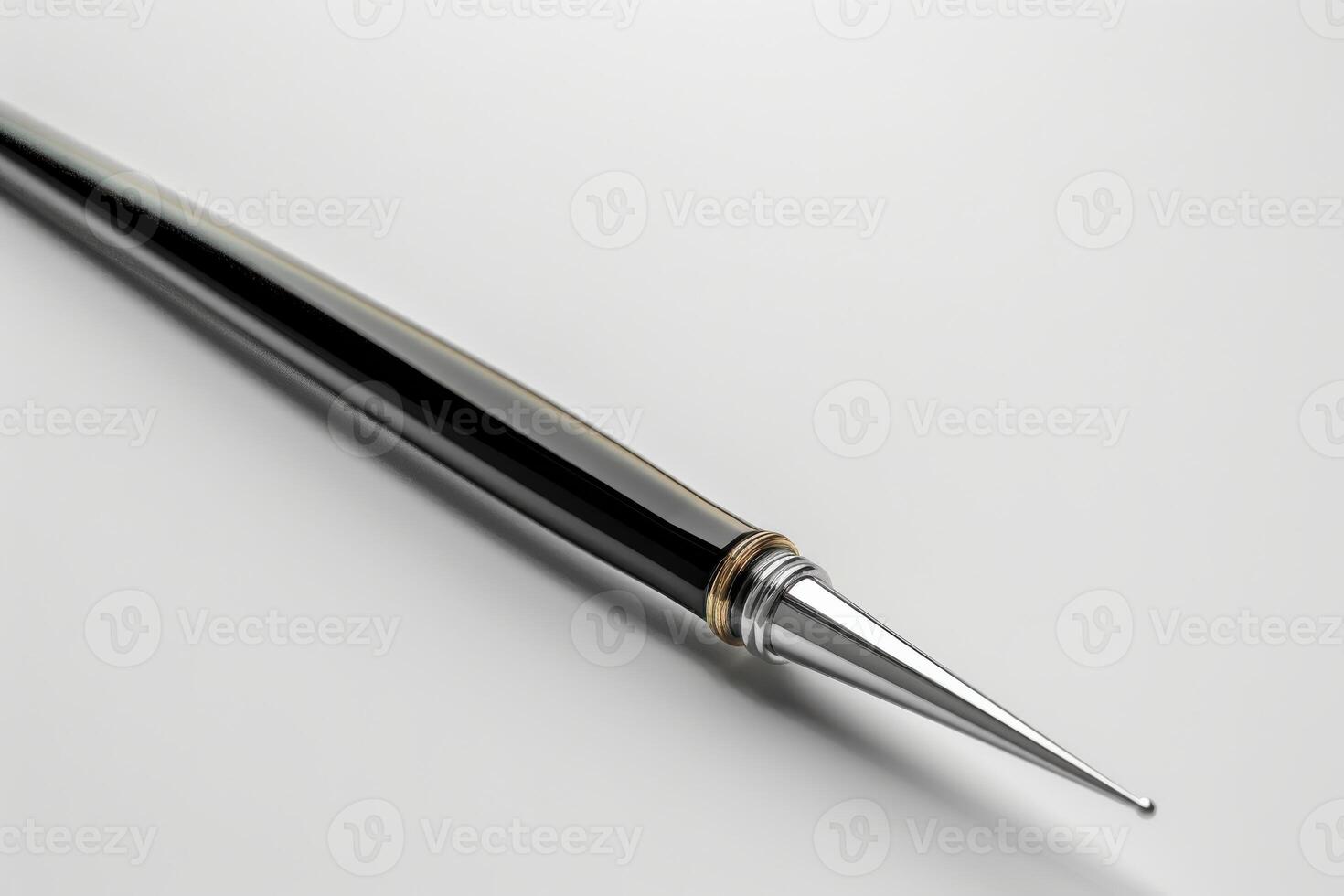 Close-up of a sleek silver and black pen resting on a white surface photo