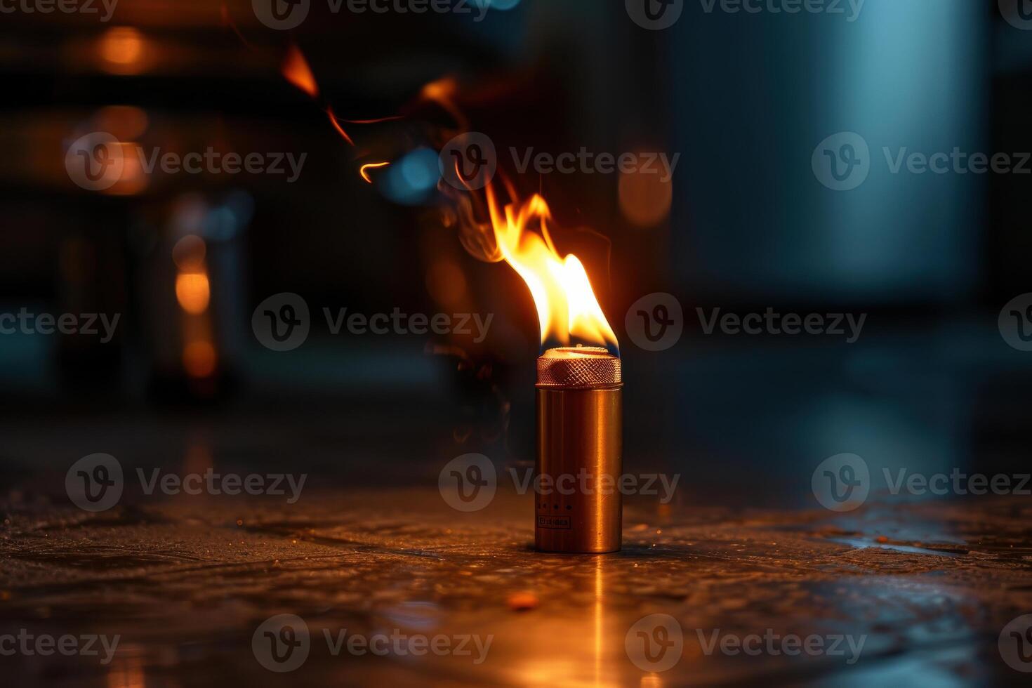 A lit lighter ignites a flame in a dimly lit indoor setting at night photo