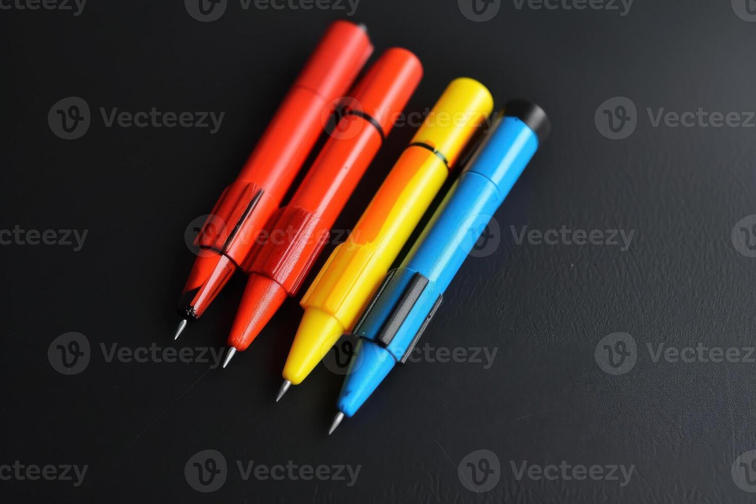 Four colorful gel pens arranged on a dark surface in a creative workspace photo