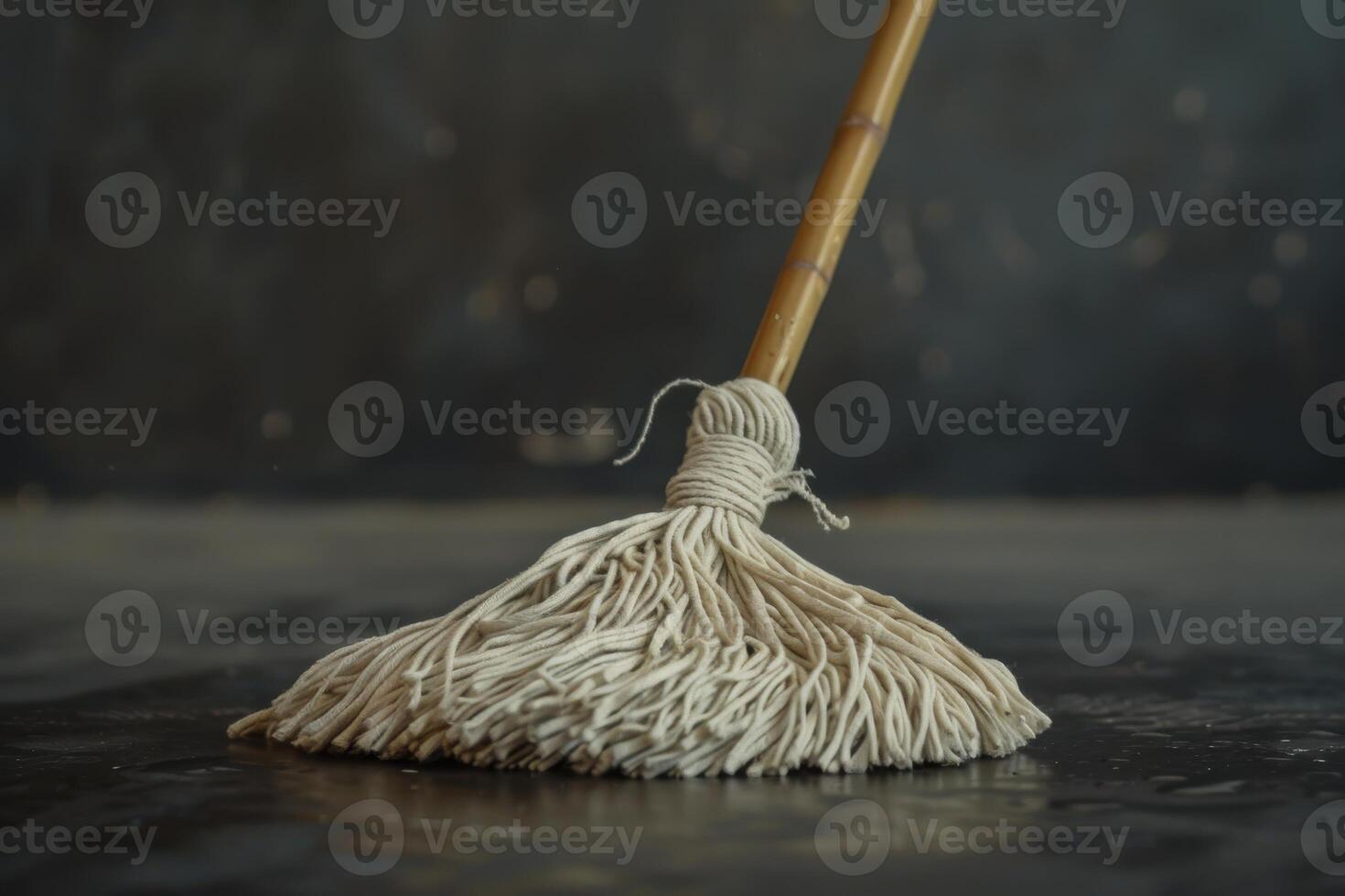 A cotton mop rests on a dark surface, highlighting its texture and material photo