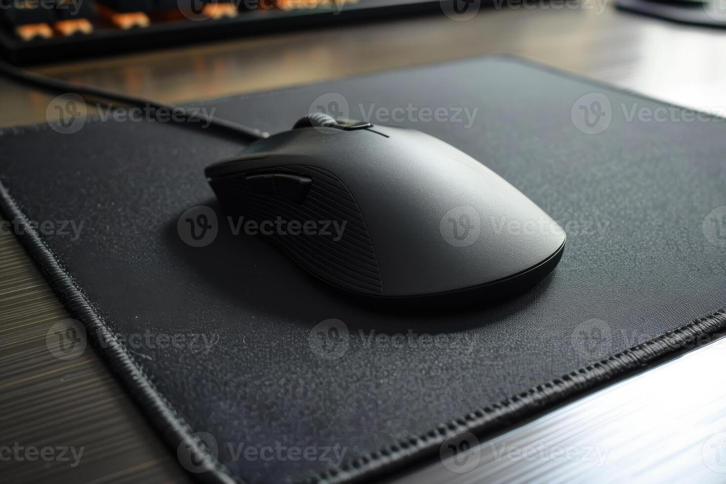 Black computer mouse resting on a sleek mouse pad in an office workspace during the day photo