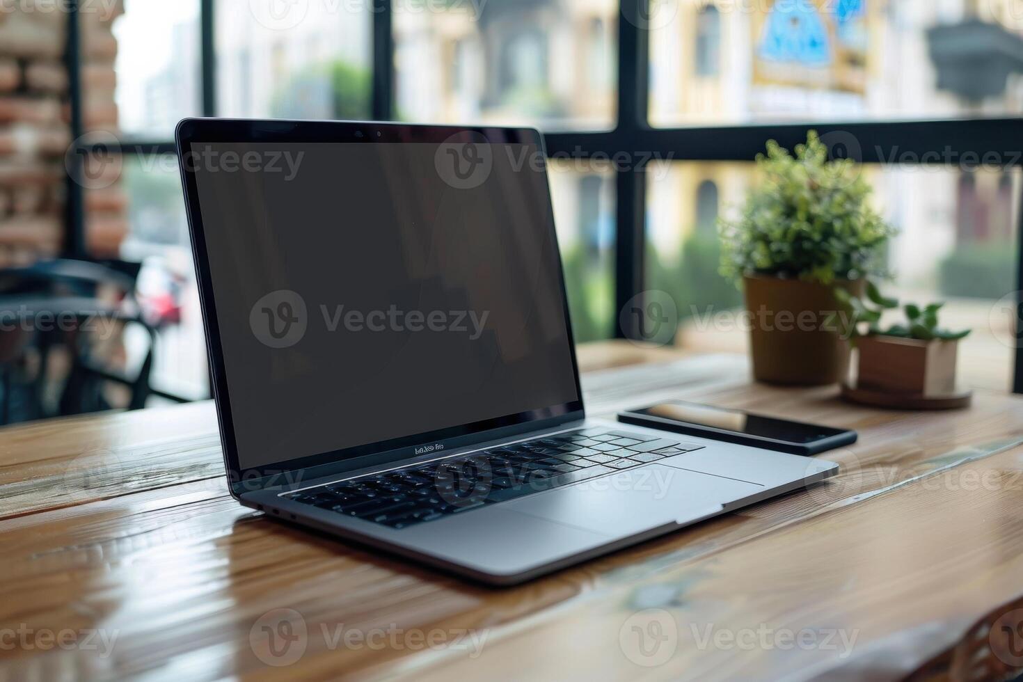 Workspace with a laptop and smartphone on a wooden table in a bright cafe during daytime photo
