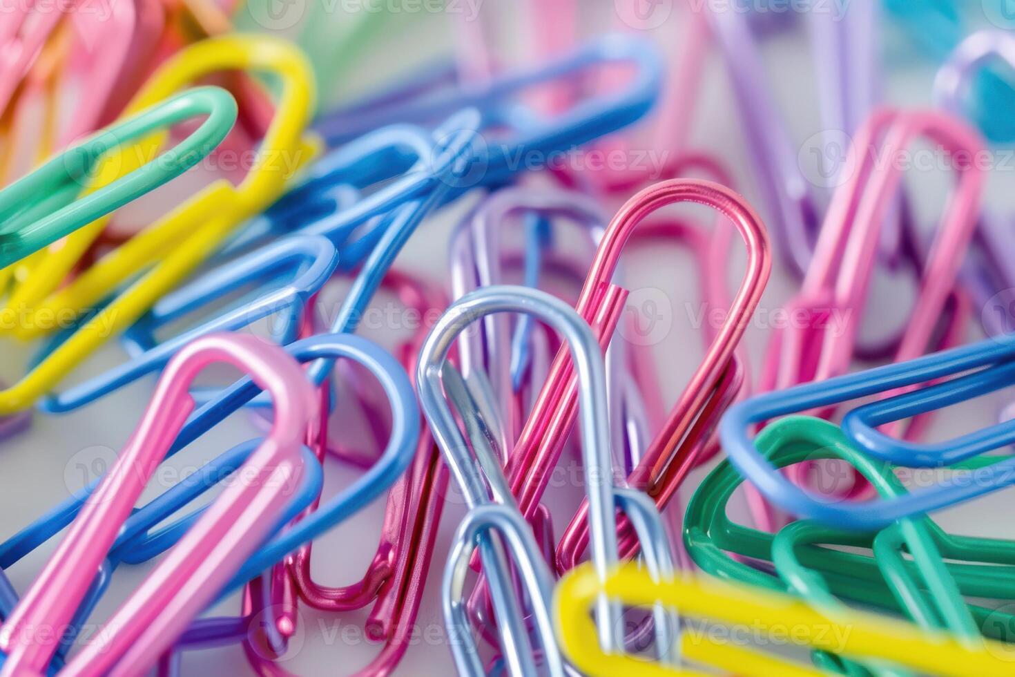 Colorful paper clips scattered on a desk surface in a creative workspace photo