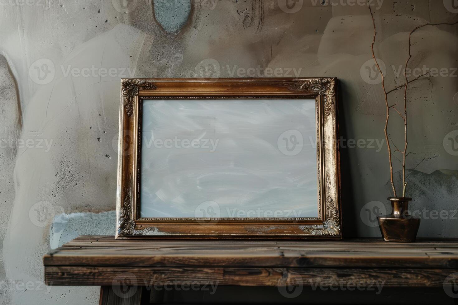 A vintage frame and simple brass vase on a rustic wooden table with a textured wall in a cozy interior setting photo