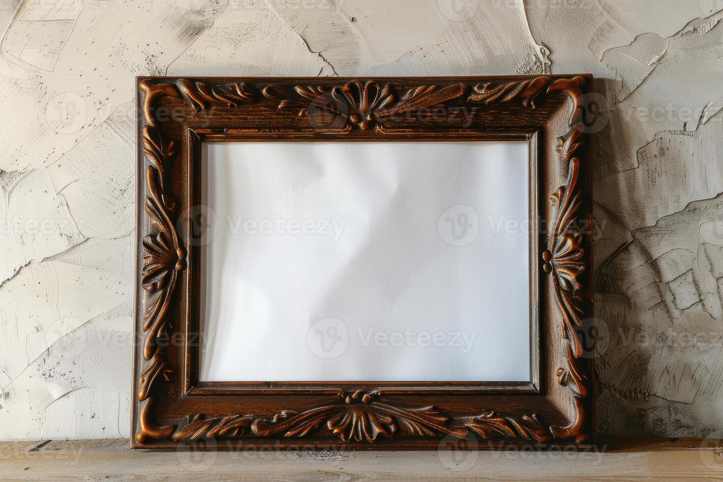 Ornate wooden picture frame resting against a textured wall with blank center, ideal for displaying art or memories photo