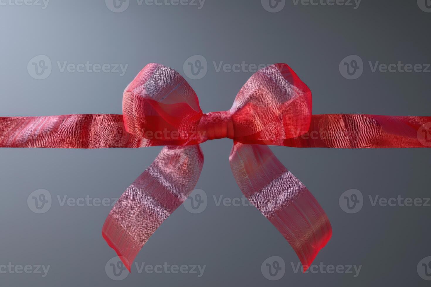 Decorative pink ribbon bow tied around a smooth surface photo