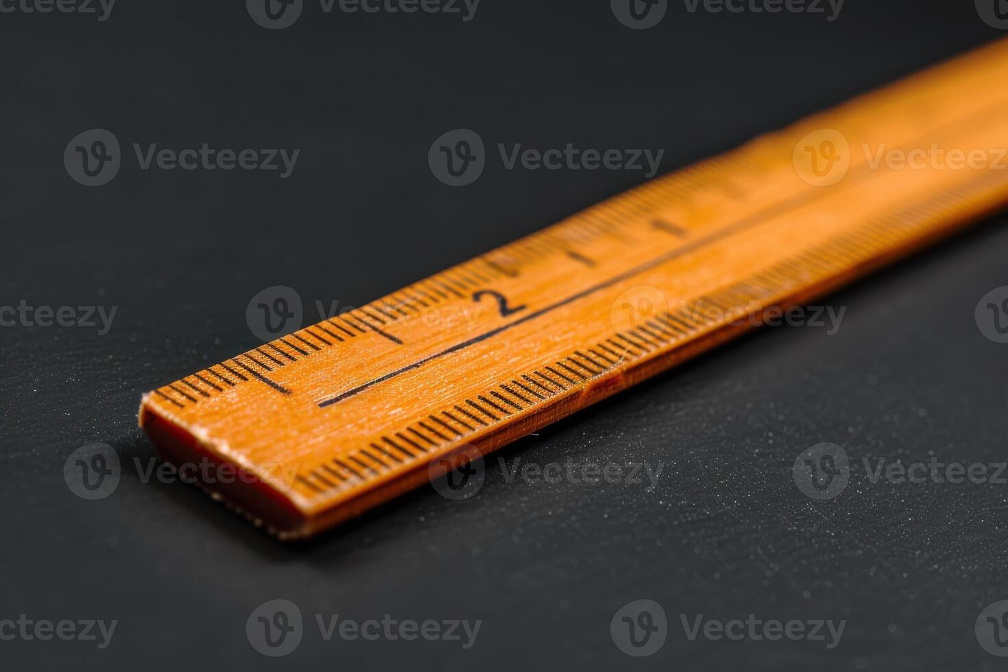 A close-up view of a wooden ruler showing measurements on a black background photo