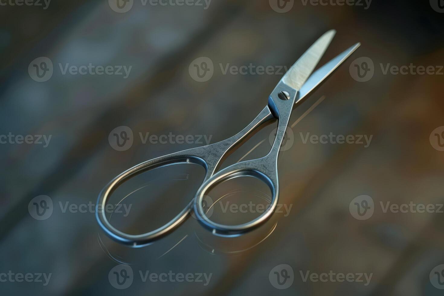 Close-up of metallic scissors resting on a reflective surface in a well-lit room during the day photo