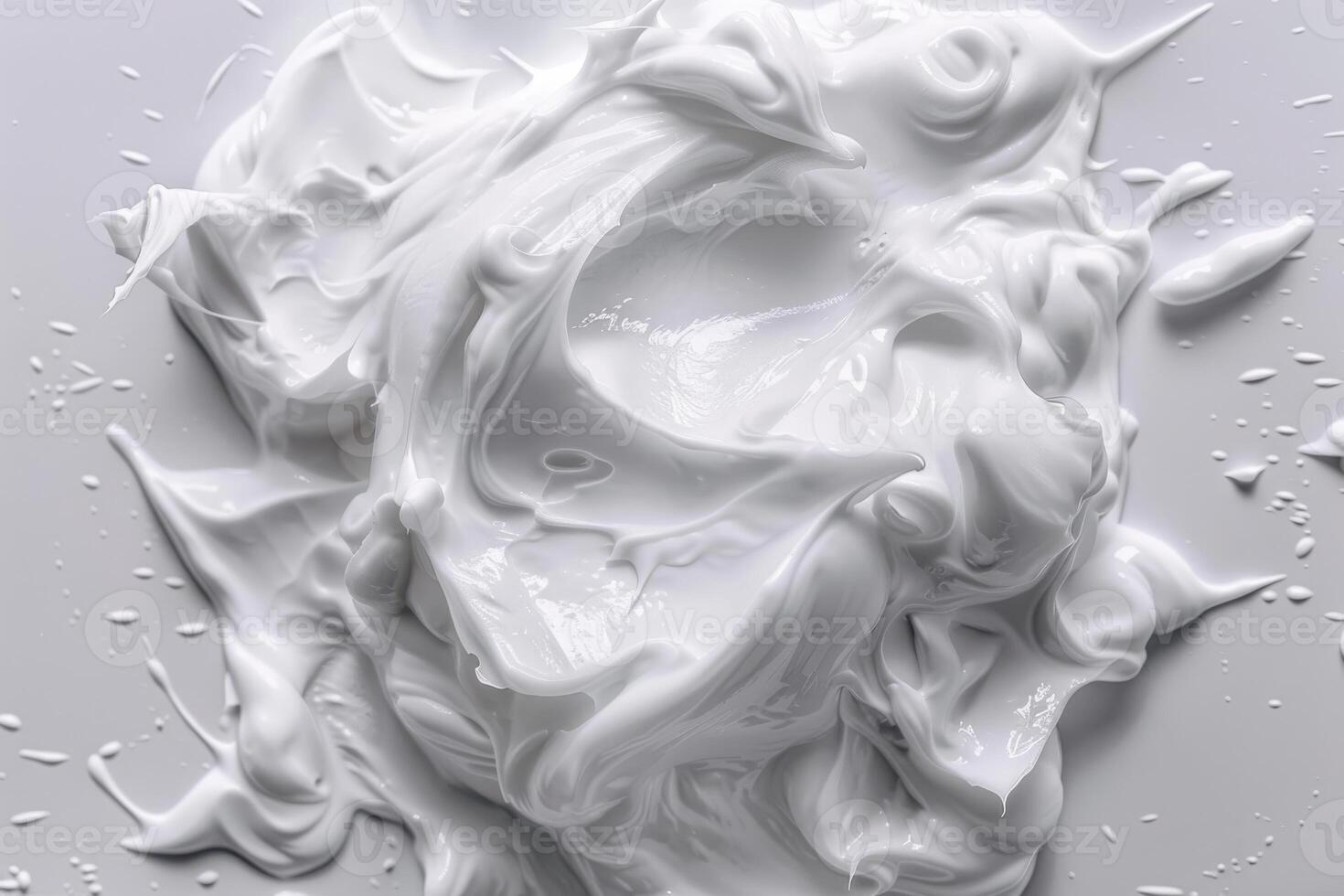 Creamy white mixture spread across a smooth surface with glossy texture and droplets photo