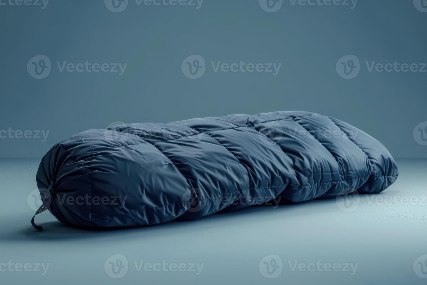Soft blue sleeping bag on a smooth surface illuminated by ambient light in a minimalist environment photo