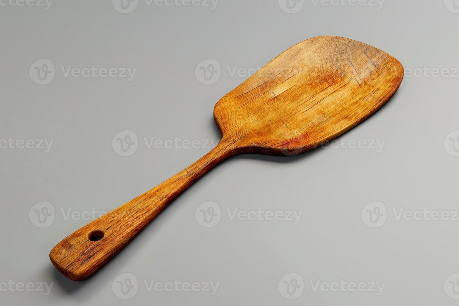 Wooden spatula resting on a grey surface in a well-lit kitchen setting photo
