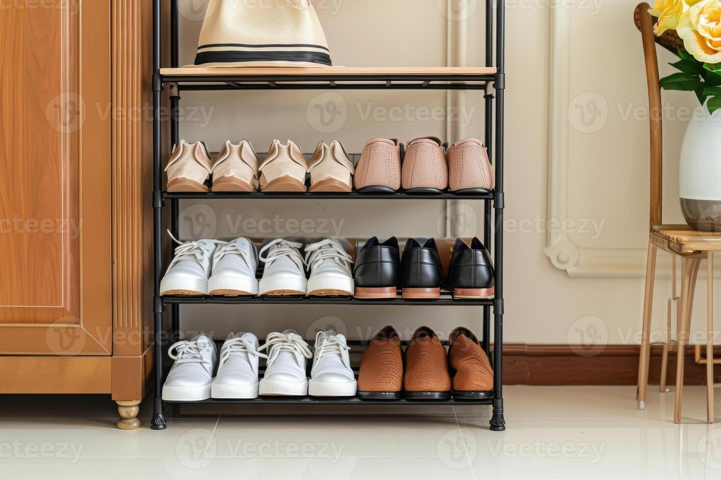 Organized shoe rack displaying various styles of footwear in a bright room with floral accents photo