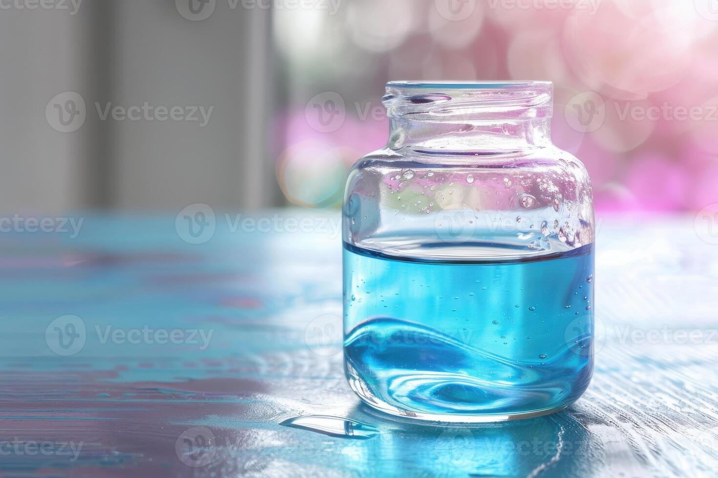 Clear glass jar filled with blue liquid on wooden table by bright window in a serene setting photo