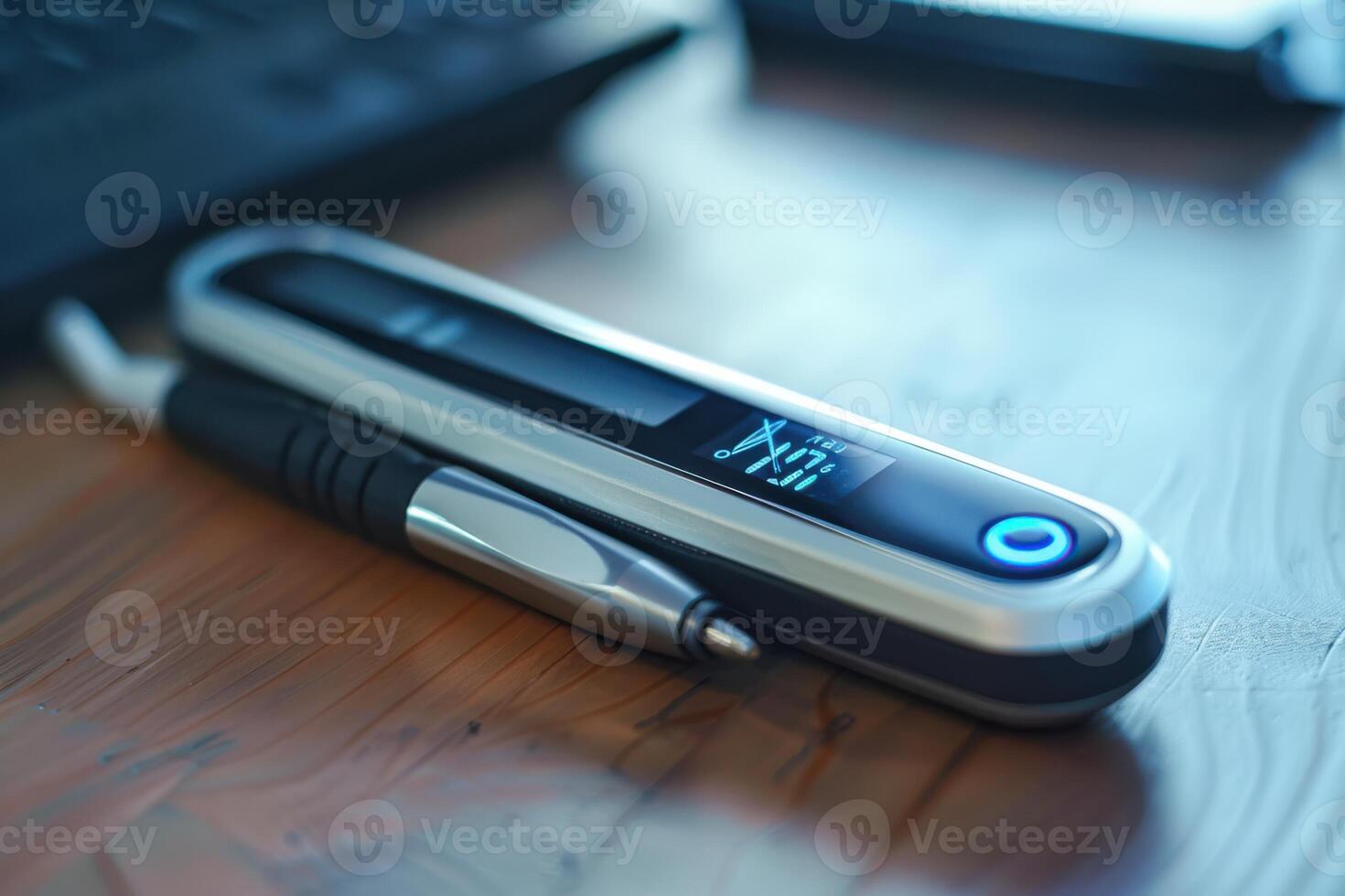 Modern digital thermometer and pen resting on a wooden desk beside a computer keyboard photo
