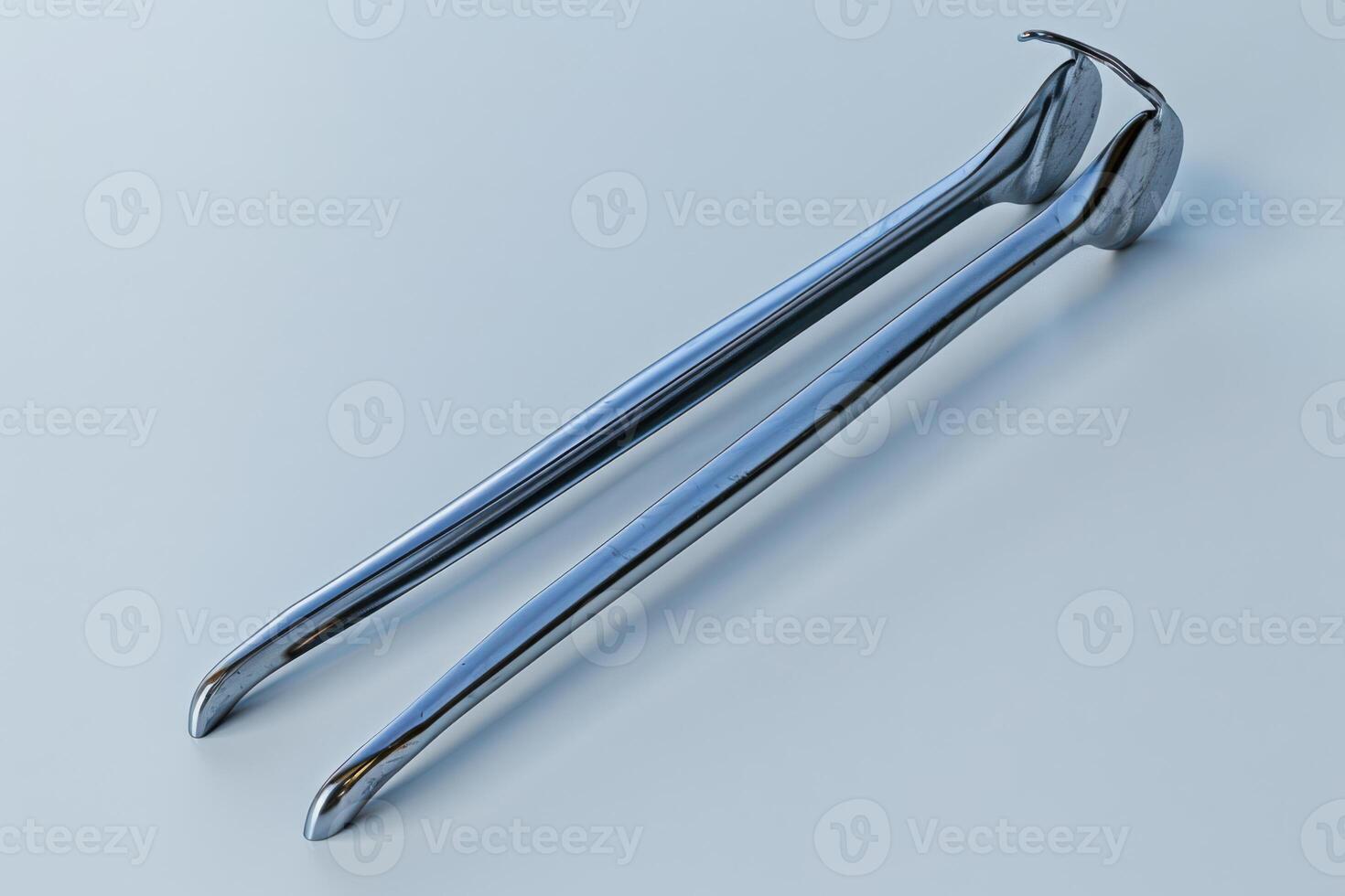 Stainless steel tongs resting on a smooth surface, reflecting light in a minimalistic setting photo