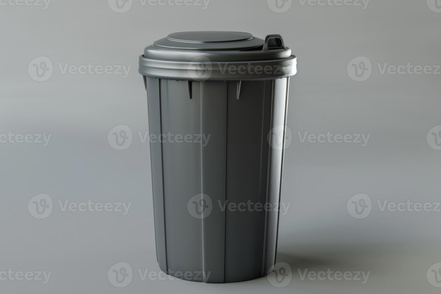 A gray trash can on a neutral background captured indoors photo