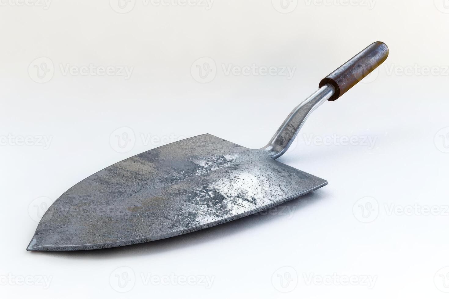 Metal garden trowel with a wooden handle resting on a light surface photo