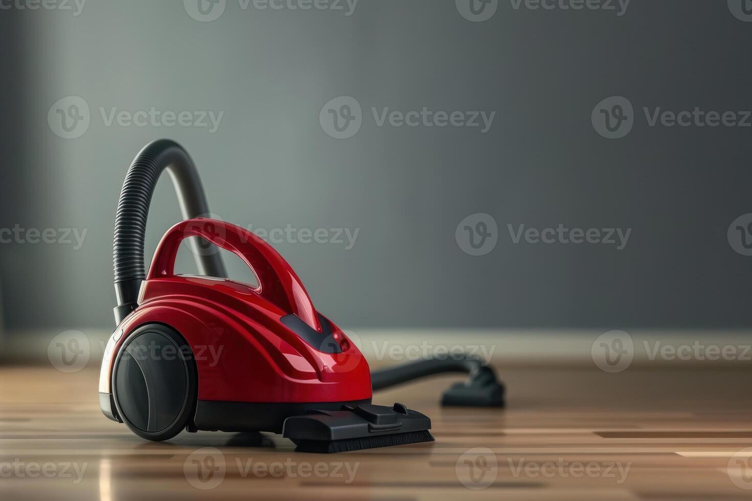 A red vacuum cleaner on polished wooden flooring in a well-lit room photo