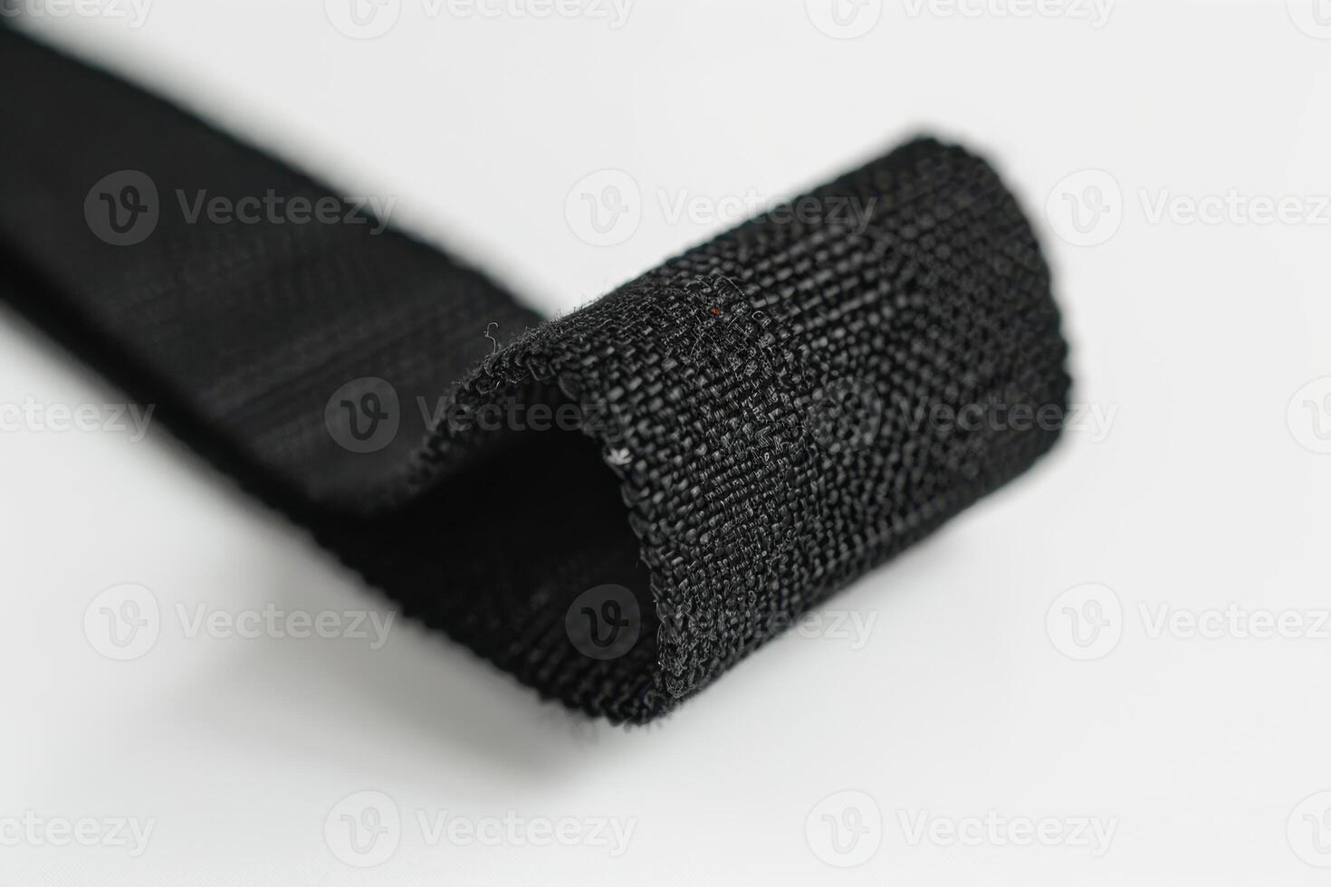 Close-up of a black textile strap with textured surface against a light background photo