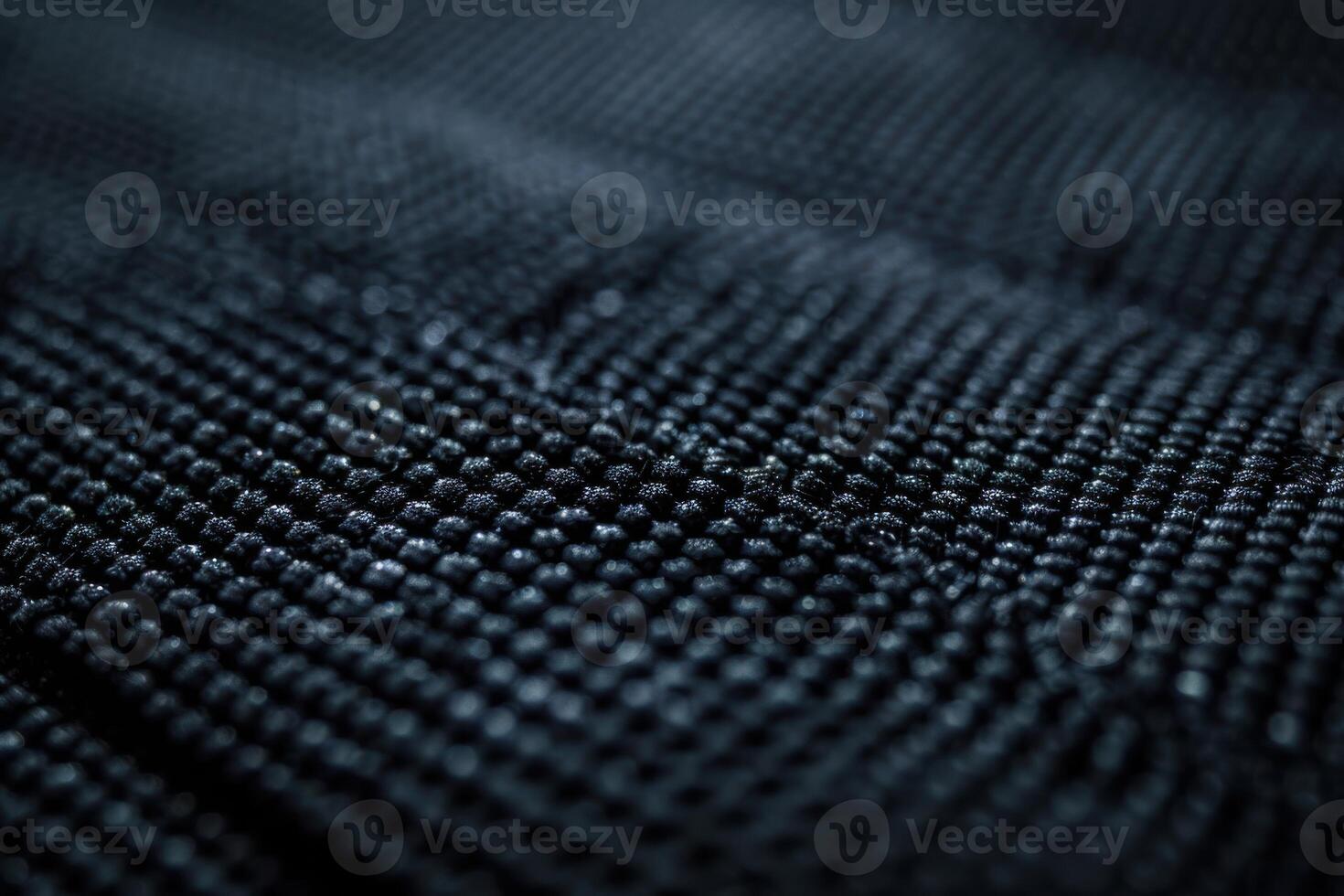 Close-up view of textured black fabric showcasing intricate weave patterns in natural lighting photo
