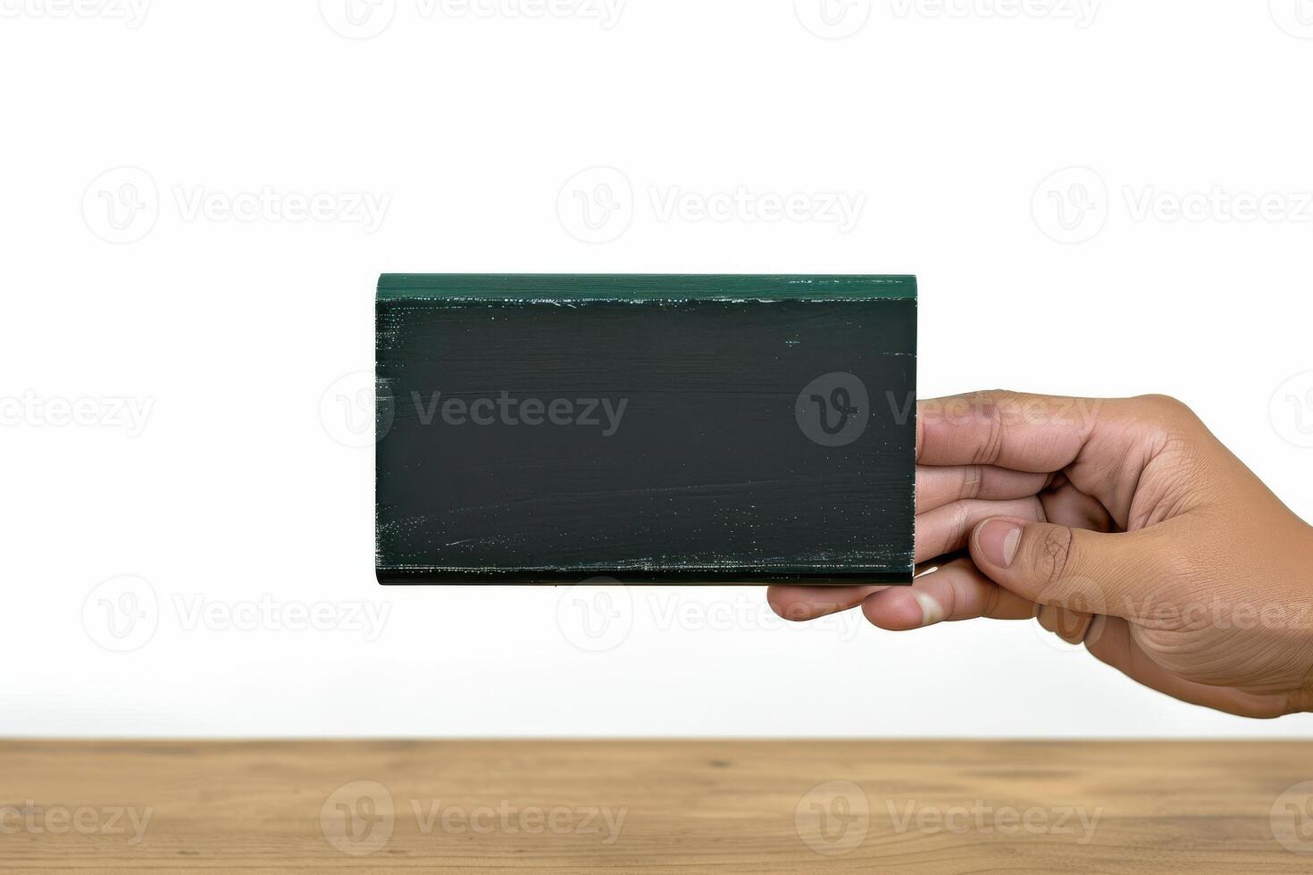 Hand holding a small blackboard against a plain white background photo