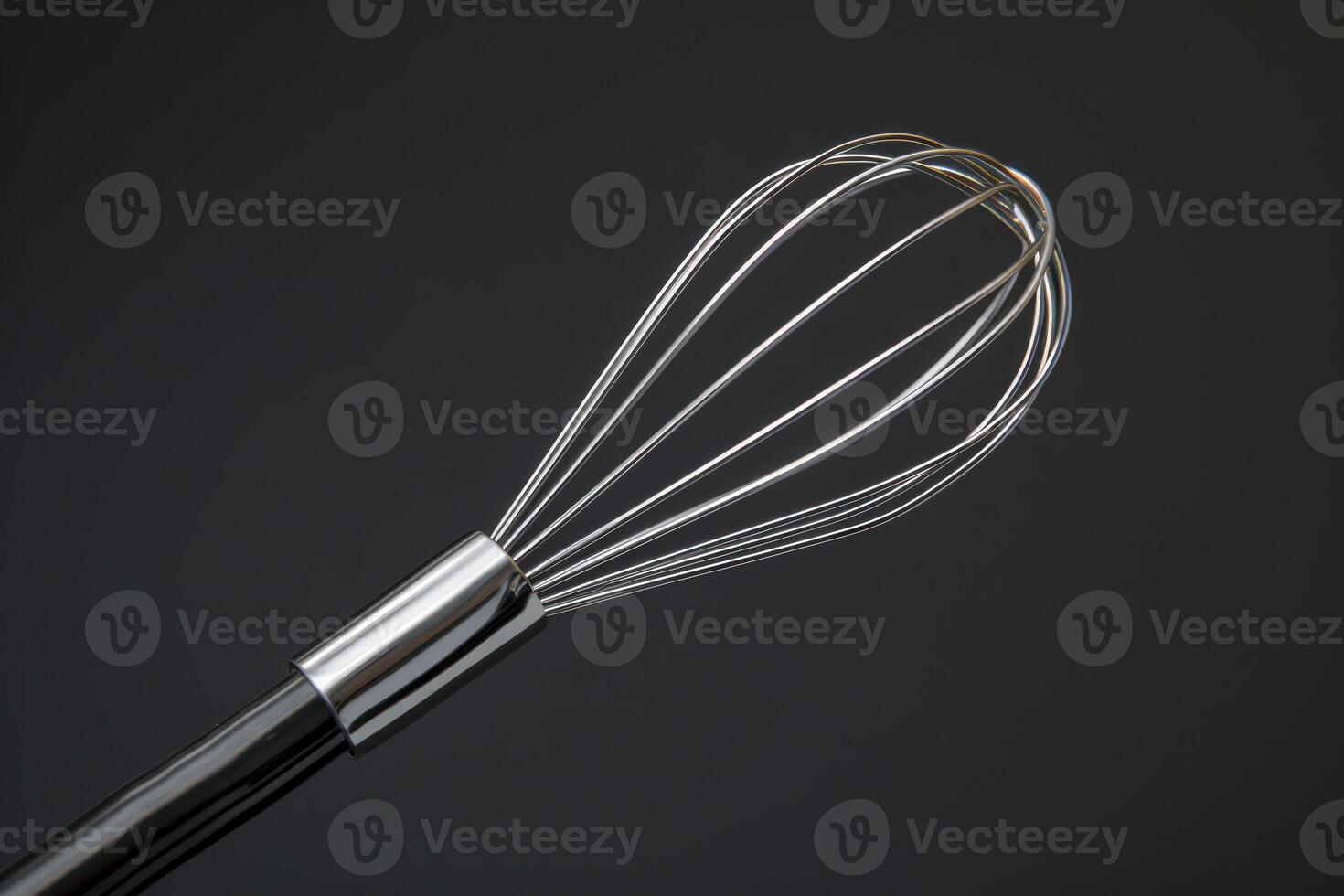 Close-up of a stainless steel whisk against a dark background showcasing its sleek design and functionality in cooking photo