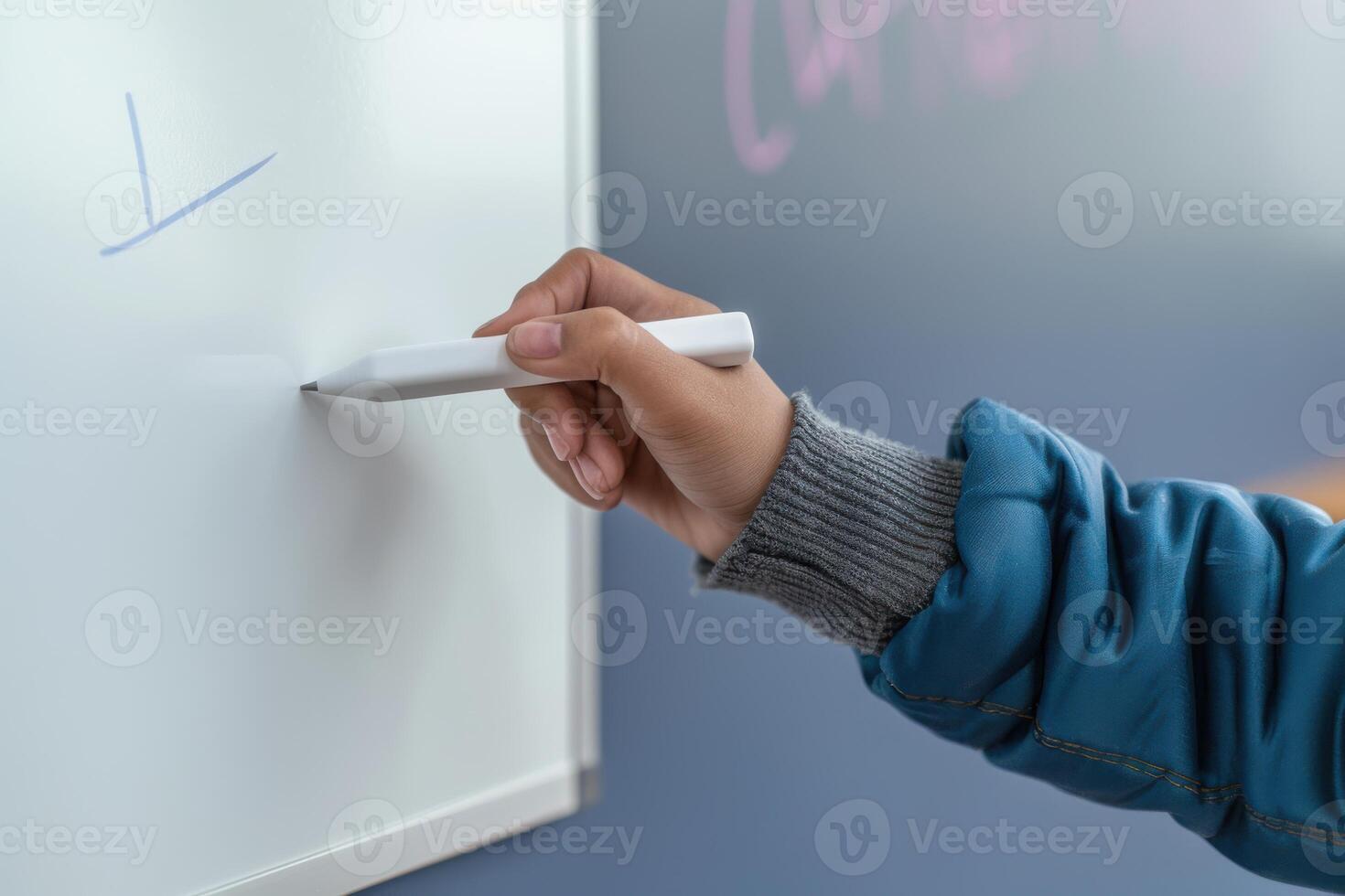 Person writing on a whiteboard during a classroom session photo