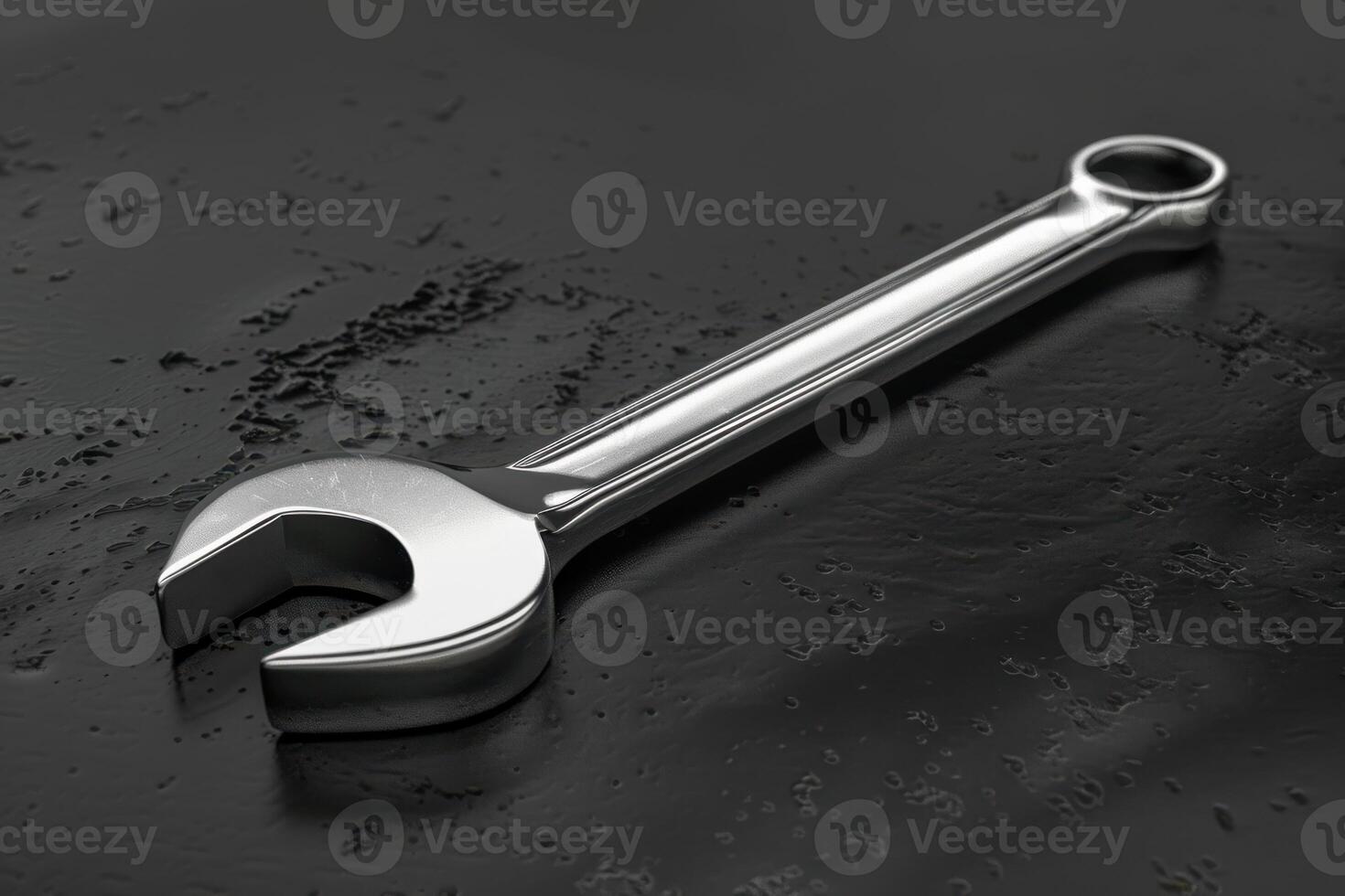 A shiny stainless steel wrench resting on a dark surface in a well-lit workshop photo