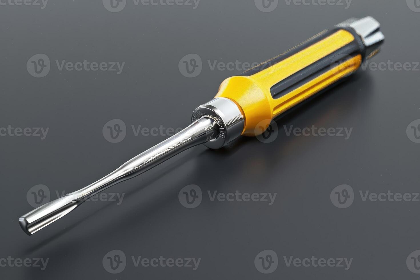 Yellow and silver screwdriver resting on a black surface, highlighting its sleek design and utility photo
