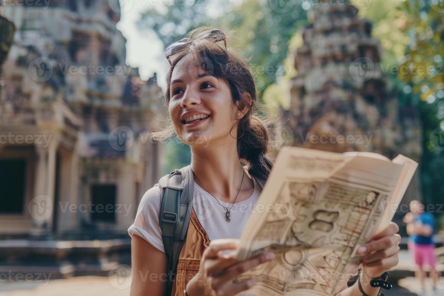 Young traveler exploring ancient temple ruins with a map in hand during a sunny day photo