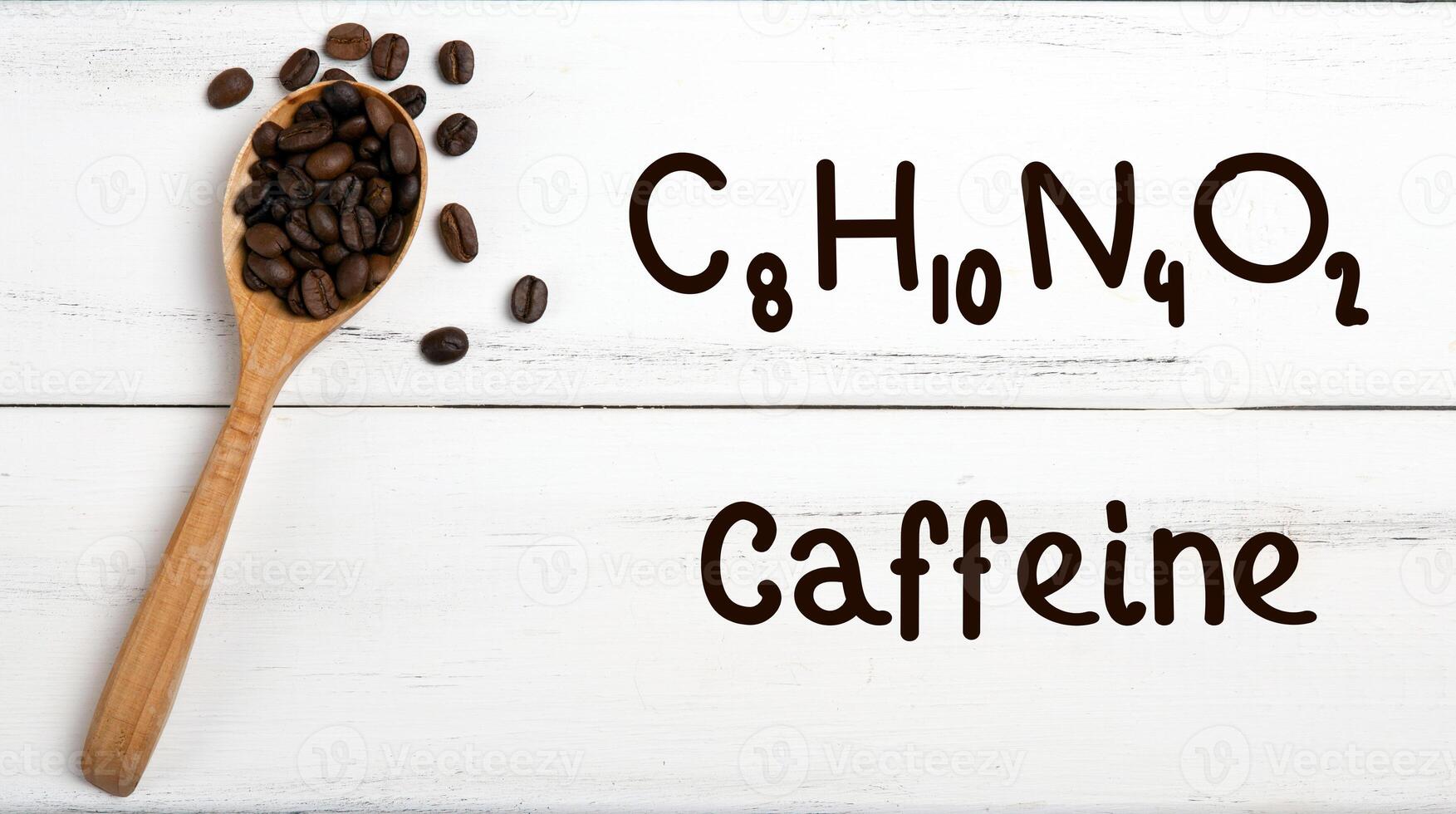 coffee beans with spoon and chemical structure of caffeine on a wooden table photo