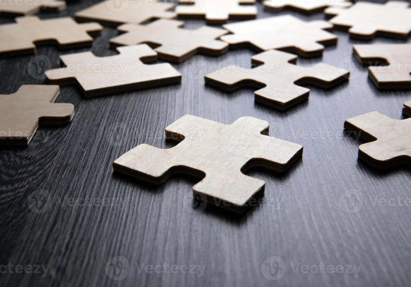 puzzle elements on a wooden background as a riddle photo