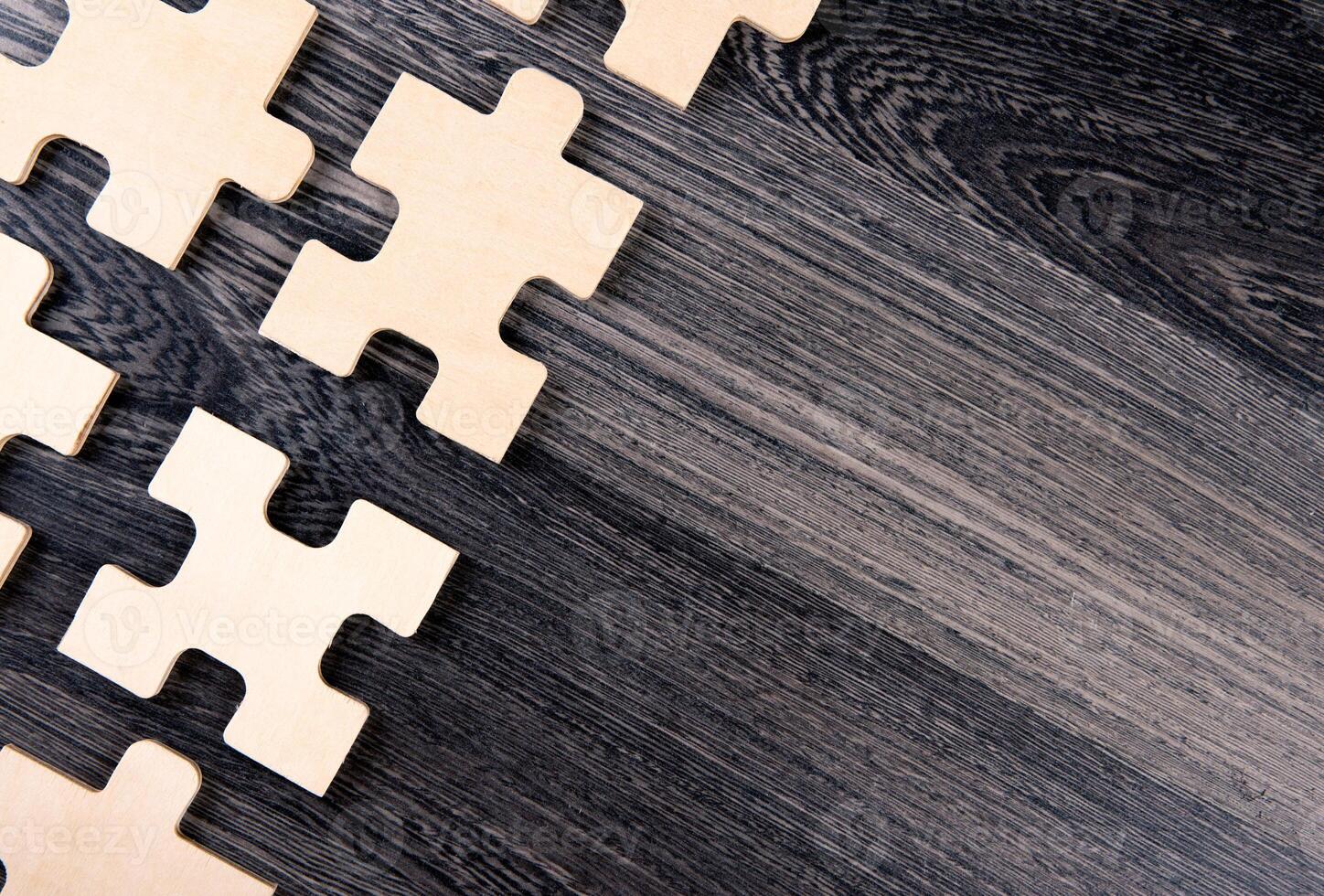 puzzle elements on a wooden background as a riddle photo