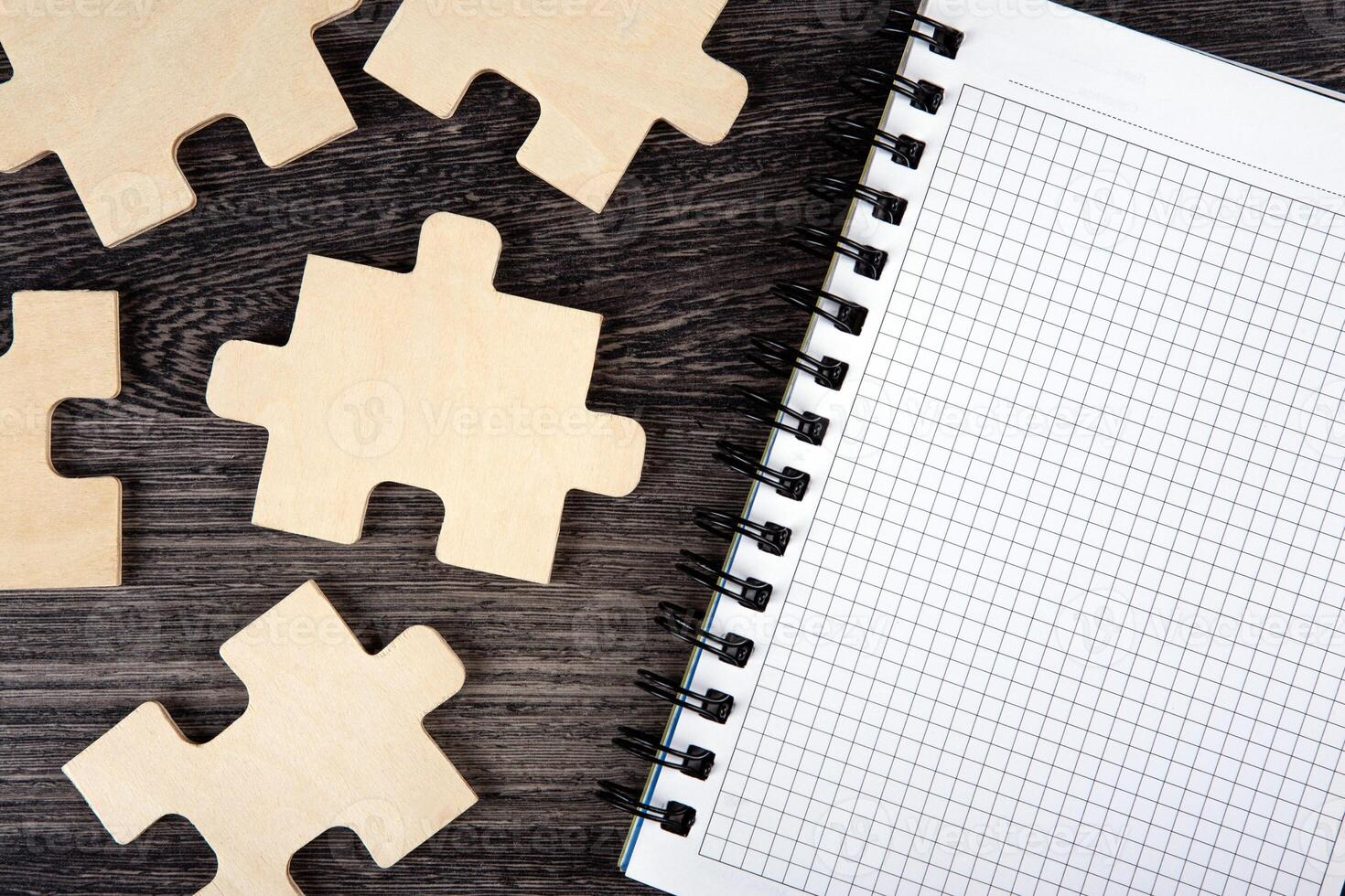 open notepad with puzzle pieces on a table photo